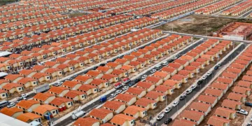 Vista aérea de condomínio com várias casas térreas de telhado vermelho alinhadas simetricamente