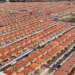 Vista aérea de condomínio com várias casas térreas de telhado vermelho alinhadas simetricamente