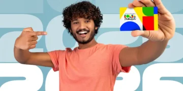 Homem sorrindo e segurando o cartão do Programa Bolsa Família 2026 com fundo destacando o ano de 2026.