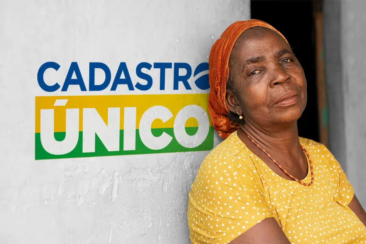 modernizacao cadastro unico 2026 cpf lei 14534 Uma mulher negra de blusa amarela de bolinhas e turbante laranja encostada em uma parede branca com o logotipo oficial do Cadastro Único ao lado.