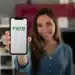 Mulher segurando smartphone com logo do GTS na tela, Fundo de Garantia do Tempo de Serviço