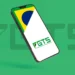 Imagem do logo do FGTS em um celular, com a bandeira do Brasil ao fundo.