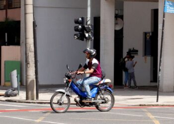 Motociclista com ciclomotor, símbolo das novas regras de registro, emplacamento e requisitos para condutores a partir de 2026.