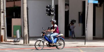Motociclista com ciclomotor, símbolo das novas regras de registro, emplacamento e requisitos para condutores a partir de 2026.
