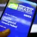 Tela de smartphone exibindo o site do Auxílio Emergencial do Governo Federal da Caixa Econômica Federal.
