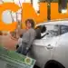 Mulher sorrindo ao lado de seu carro, segurando as chaves enquanto a CNH está em primeiro plano, com foco na renovação automática.