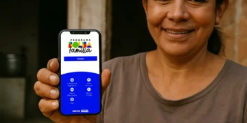 Mulher segurando celular com aplicativo do Bolsa Família para consultar valor do benefício.