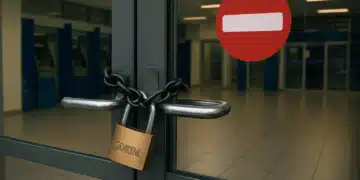 Porta de vidro com corrente e cadeado em agência bancária vazia