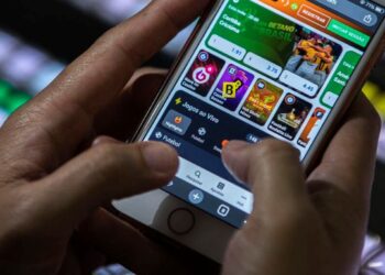 Pessoa usando aplicativo de apostas no celular, ilustrando o tema de vício em apostas tratado pelo SUS.