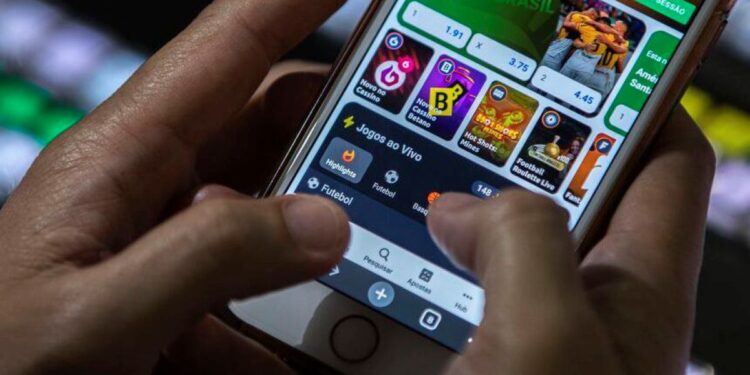 Pessoa usando aplicativo de apostas no celular, ilustrando o tema de vício em apostas tratado pelo SUS.