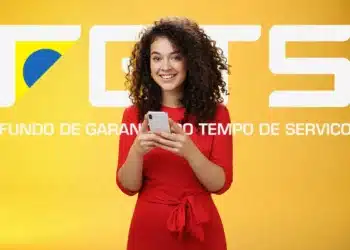 Mulher sorridente vestindo vestido vermelho segurando um celular com o logo do FGTS ao fundo amarelo