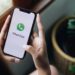 Pessoa segurando celular com aplicativo WhatsApp aberto, recebendo mensagem