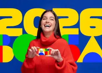 Mulher sorrindo segurando cartão do Bolsa Família com fundo colorido