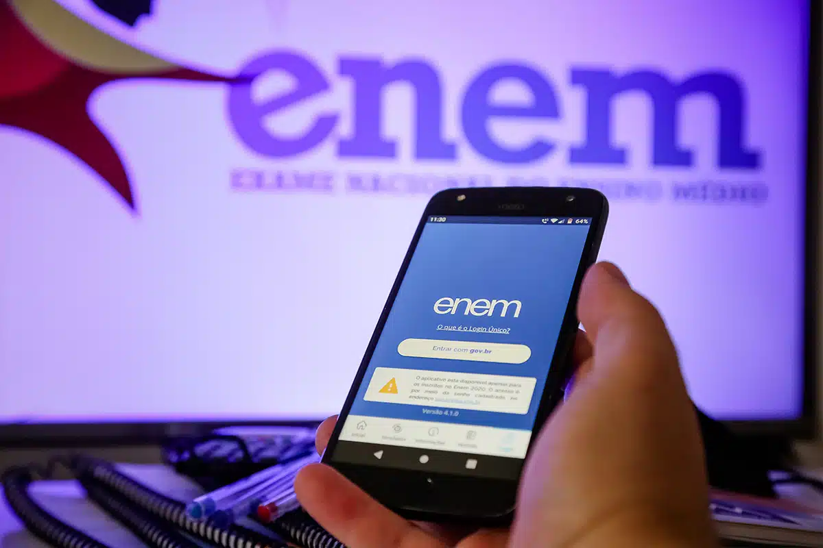 Celular com tela do Enem aberto na mão do usuário