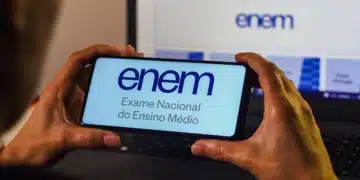Pessoa segurando celular com página do Enem aberta