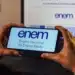 Pessoa segurando celular com página do Enem aberta