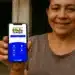 Mulher mostrando celular com aplicativo do Bolsa Família aberto