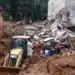 Equipes de bombeiros e maquinário escavam escombros de casas destruídas por deslizamento de terra em Minas Gerais.