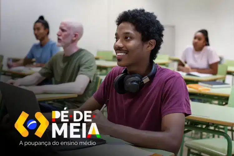 Jovem negro com fone de ouvido no pescoço sorrindo em sala de aula usando notebook, com logo Pé-de-Meia visível.