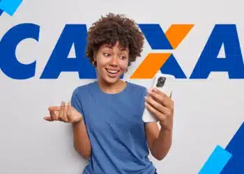 Jovem negra com cabelo crespo, camiseta azul, segura iPhone branco, olhando a tela com expressão de surpresa e gesticulando