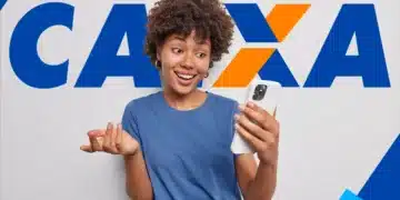 Jovem negra com cabelo crespo, camiseta azul, segura iPhone branco, olhando a tela com expressão de surpresa e gesticulando