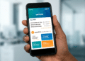 Mão segurando smartphone com aplicativo FGTS da Caixa mostrando saldo total de R$ 6.336,33 de contas ativas e inativas