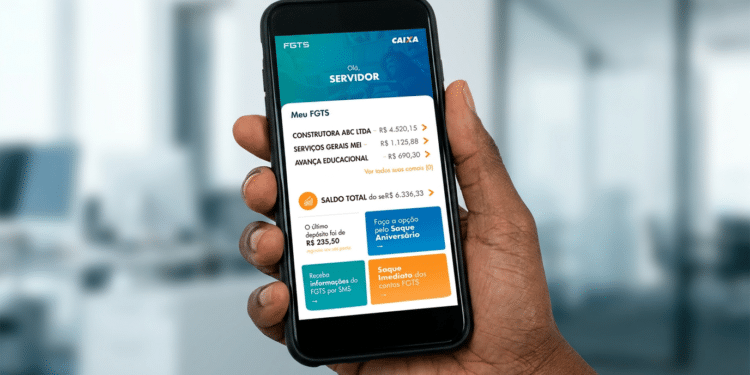Mão segurando smartphone com aplicativo FGTS da Caixa mostrando saldo total de R$ 6.336,33 de contas ativas e inativas