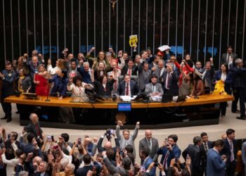 Parlamentares erguem punhos e cartazes no plenário da Câmara após aprovação da PEC que acaba com a escala 6x1