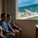 Família assiste à TV em casa enquanto antena parabólica aparece pela janela