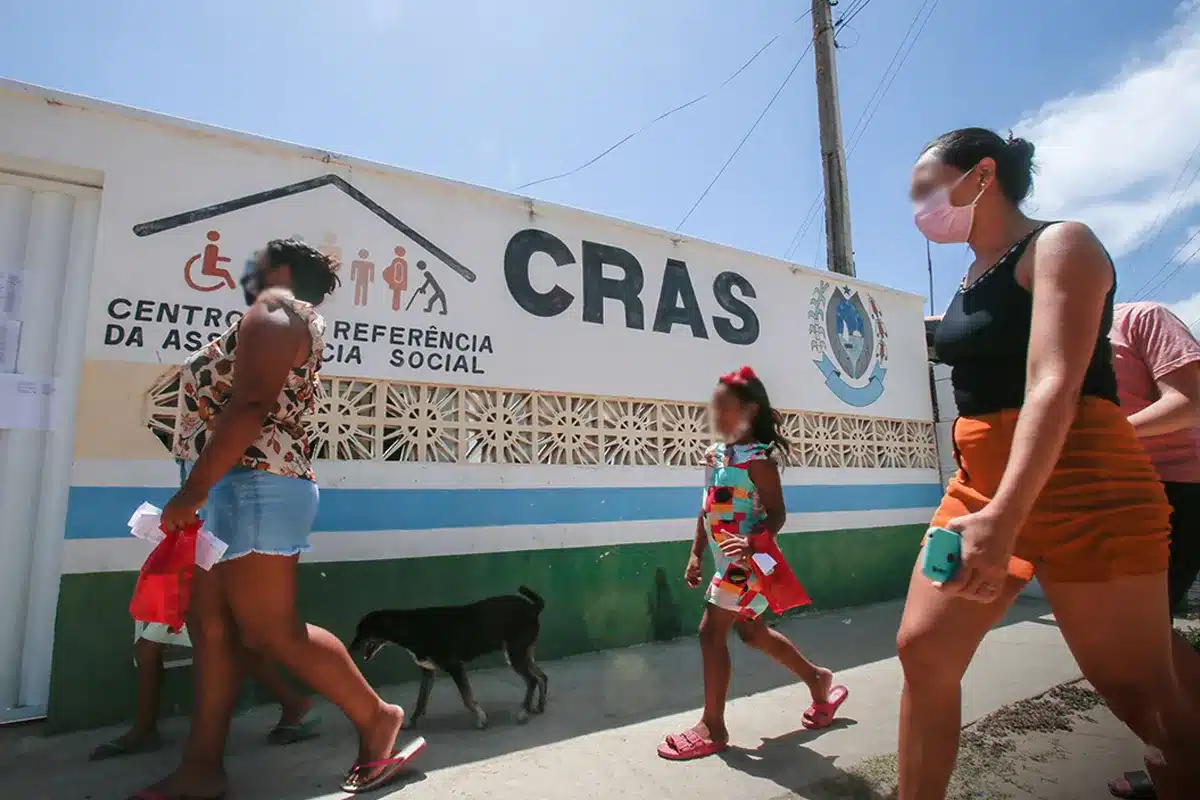 Famílias caminhando em frente a unidade do CRAS