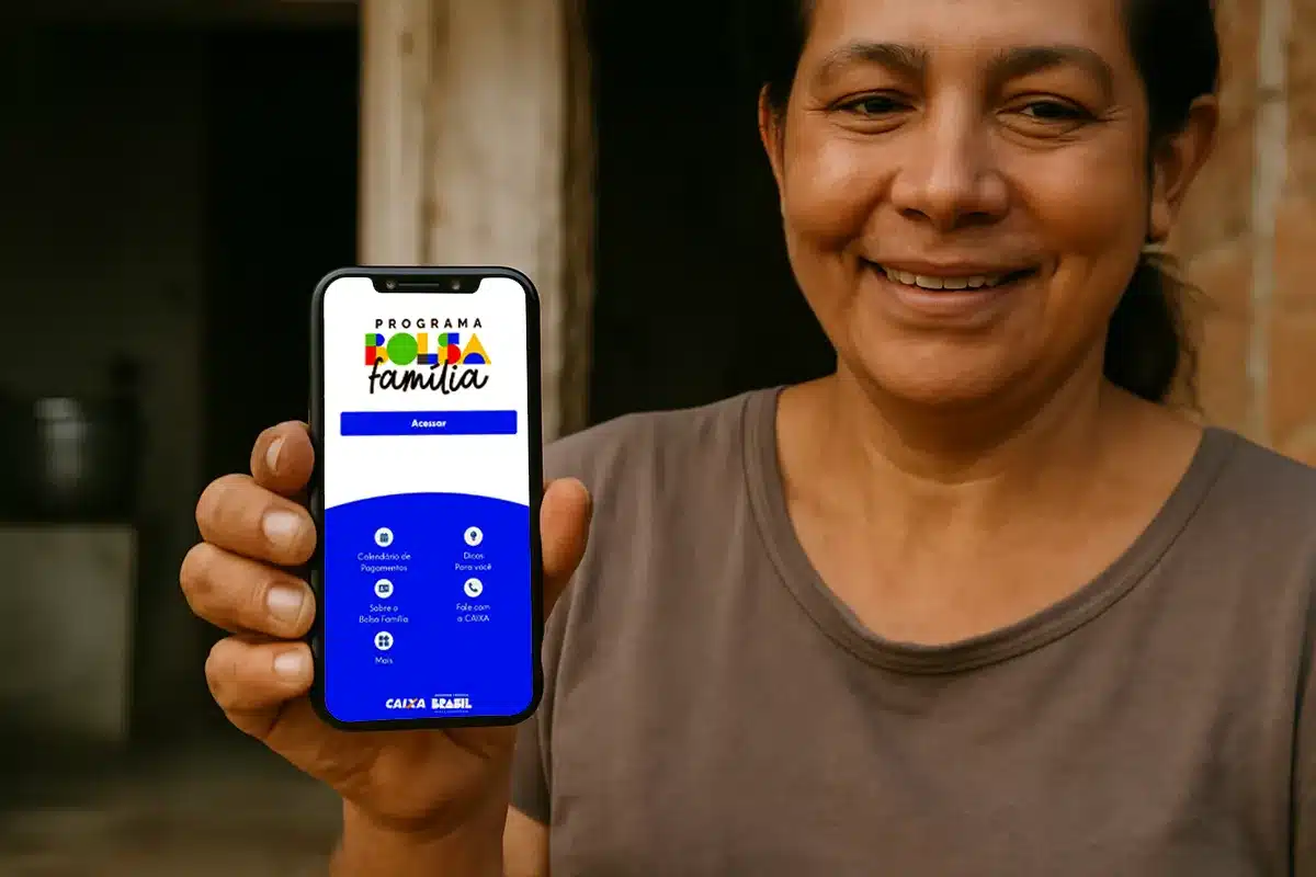 Mulher segurando celular com aplicativo do Bolsa Família para consultar benefício bloqueado