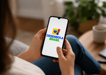 Pessoa segurando celular com a logo do programa Desenrola Brasil aberta na tela