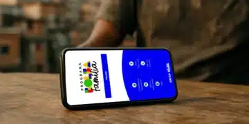 Celular com aplicativo do Bolsa Família aberto sobre mesa