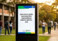 Totem digital exibe aviso do MEC sobre encerramento das inscrições do ENCCEJA 2026 em campus universitário.