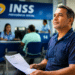 Homem aguarda atendimento segurando um documento na sala de espera de uma agência do INSS