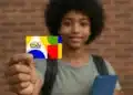 Estudante segurando cartão do Bolsa Família representando regras de frequência escolar do benefício