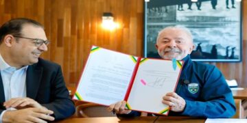 Presidente Lula exibe documento assinado da lei CNH do Brasil ao lado do ministro George Santoro no Palácio da Alvorada