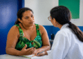 Mulher conversa com profissional em posto de saúde
