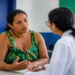 Mulher conversa com profissional em posto de saúde