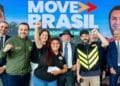 Grupo com autoridades, entregadores sorrindo e braço erguido, fundo Move Brasil azul