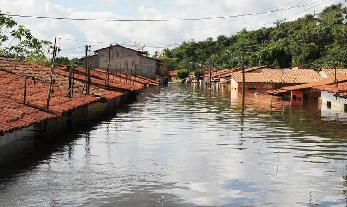 Até R$ 1.621 na conta: Abono Salarial foi antecipado para trabalhadores de municípios mineiros 2 Casas com telhados de barro parcialmente submersas por enchente, água tomada nas ruas