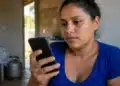 Mulher consulta pelo celular, no app Meu Social, informações sobre o vale-recarga do Gás do Povo.