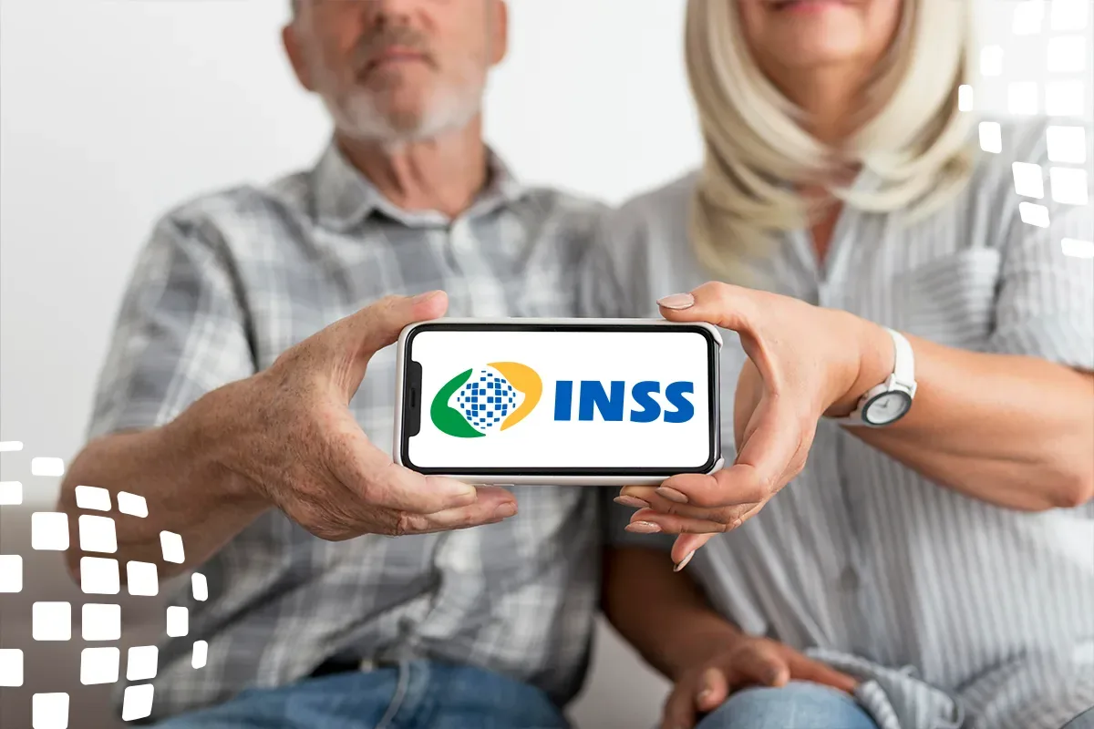 Segurados do INSS começam a receber pagamento de agosto: calendário vai até 8 de setembro 2 Casal segura celular com símbolo do INSS, representando a consulta de valores e extratos do benefício pelos canais digitais.