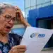 Adeus Meu INSS Vale+: INSS encerra antecipação de até R$ 450 para aposentados e pensionistas 14 Aposentada analisa documento do INSS em frente a uma agência após encerramento do Meu INSS Vale+
