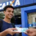 Estudante segurando dinheiro em frente a uma agência da Caixa, representando o pagamento do Pé-de-Meia.