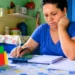 Orçamento 2027: Bolsa Família não terá aumento da parcela; piso segue sem reajuste desde 2023 14 Mulher faz cálculos do orçamento doméstico diante de material do Bolsa Família, representando a manutenção do benefício em 2027.