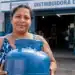 Gás do Povo de setembro: 4,2 milhões de famílias têm vale-recarga liberado nesta quinta-feira (10) 14 Mulher segura botijão de gás em frente a distribuidora representando a liberação do vale-recarga do Gás do Povo para famílias beneficiadas em setembro