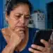 INSS faz novo alerta a beneficiários sobre mensagens falsas que ameaçam cortar benefício por falta de prova de vida 14 Beneficiária do INSS observa celular preocupada com mensagem falsa sobre prova de vida