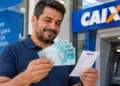 Homem confere dinheiro e comprovante bancário, representando o pagamento do lote residual da restituição do Imposto de Renda.