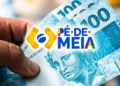 Mão segurando notas de dinheiro de R$ 100 com a marca do programa Pé-de-Meia ao centro da imagem.